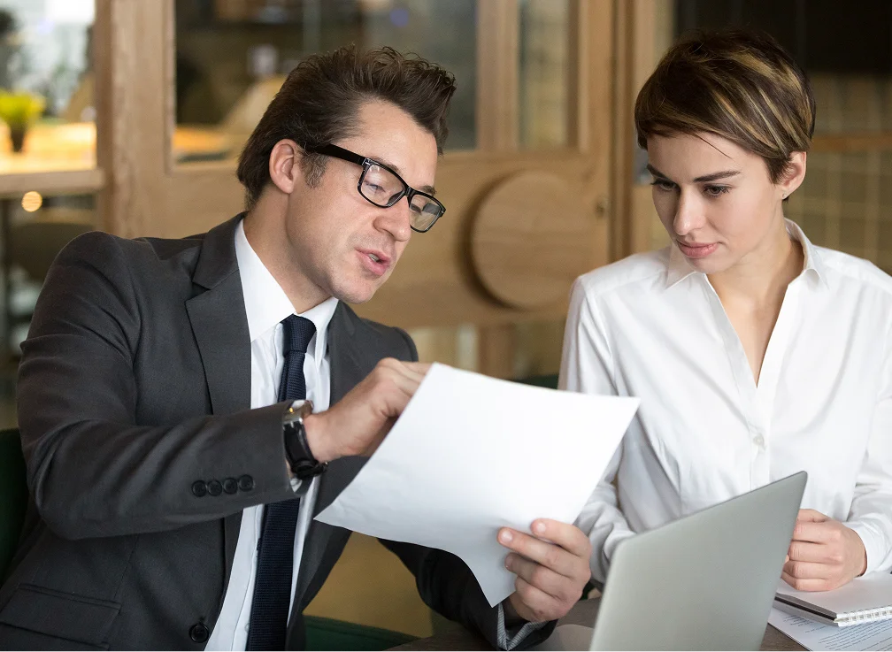 Two professionals discussing a document at a table