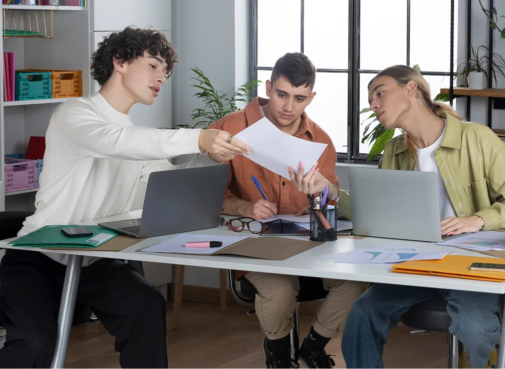 Three young professionals collaborating in a modern office setting