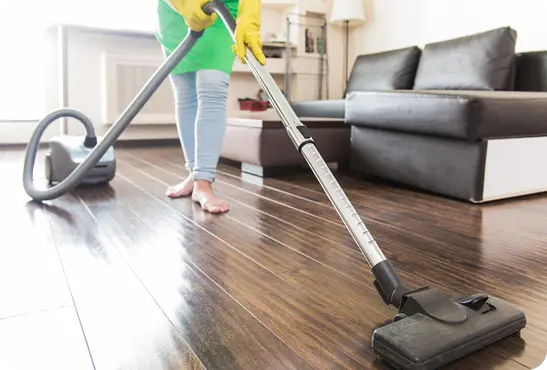 A woman vacuuming a hardwood floor